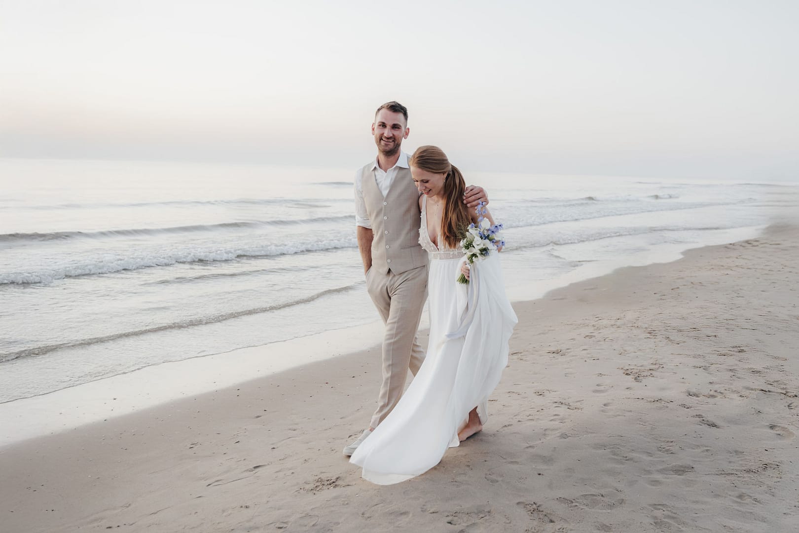 Brautpaar bei einem Spaziergang am Strand