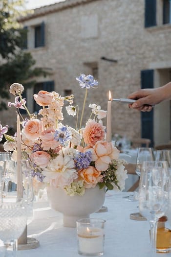 Weddingplanner zündet Kerzen an einer liebevoll gedeckten Hochzeitstafel für eine Hochzeit unterm Sternenhimmel