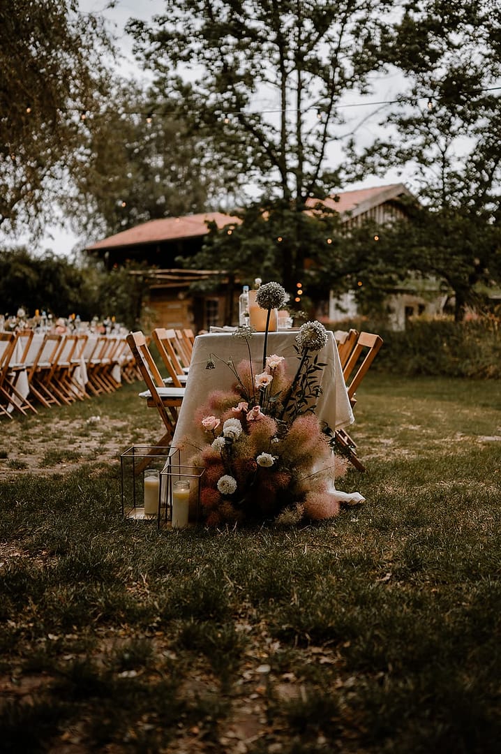 Lange Tafel für das Hochzeitsdinner im Garten eines Ferienhauses, gestaltet für eine stilvolle Outdoor- und Garten Hochzeit.