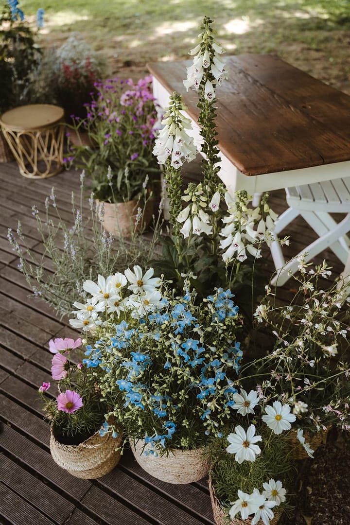 Natürliche Blumendekoration mit Sommerblumen für eine Outdoor Hochzeit in persönlichem Rahmen