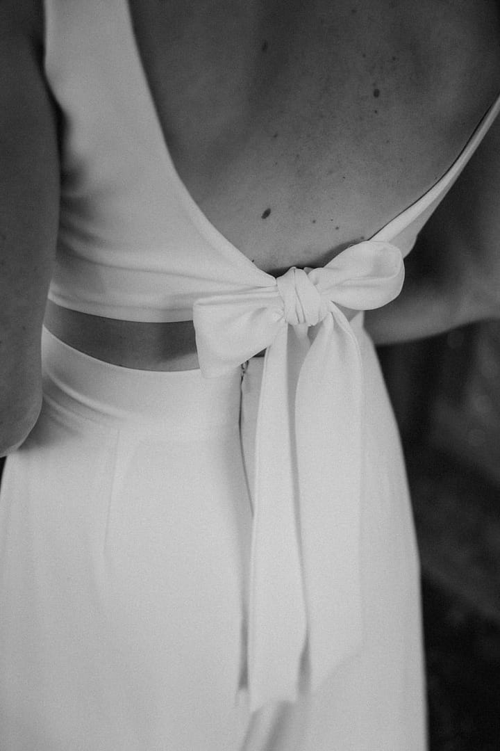 Detailaufnahme eines modernen Brautoutfits mit Hose – klare Linien und zeitlose Hochzeitsästhetik