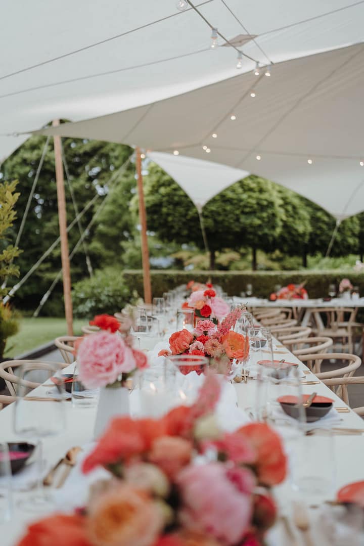 Elegantes Dinner-Setup unter einem Stretchzelt bei einer Gartenhochzeit auf einem privaten Estate
