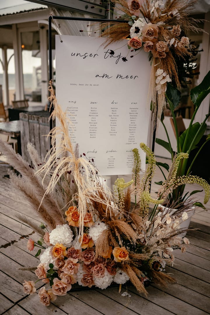 Sitzplan mit floraler Dekoration bei einer Hochzeit am Meer in Holland