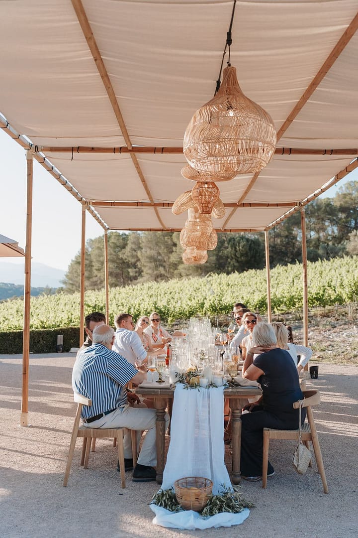 Lange Tafel unter Stoffdach bei einer Destination Wedding im Weinberg – geplant von einem Hochzeitsplaner