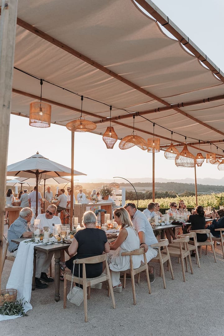 Gemeinsames Dinner beim Wedding Weekend unter freiem Himmel – Outdoor Hochzeit mit langer Tafel und Abendlicht