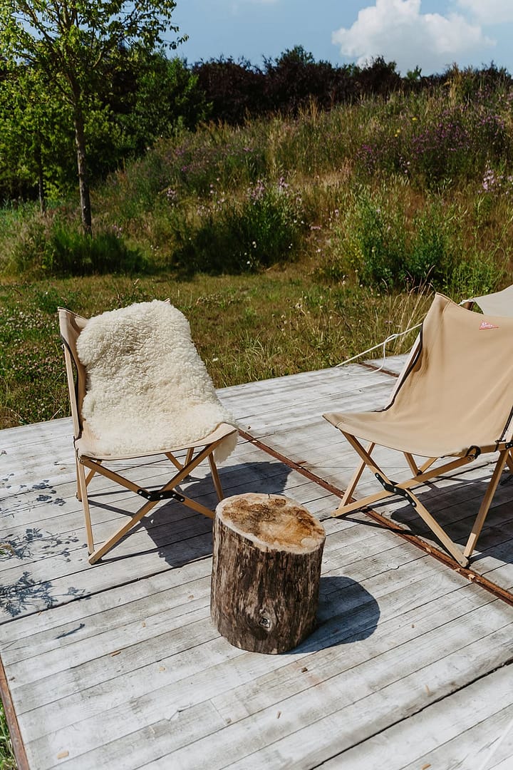 Zwei Lounge-Stühle auf einem Holzdeck inmitten einer natürlichen Wiesenlandschaft – entspannter Outdoor-Bereich für ein Event oder Hochzeitswochenende