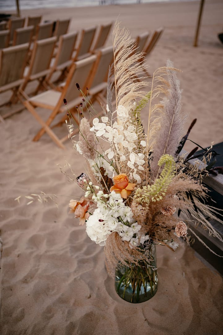 Blumenarrangement in warmen Naturtönen bei einer Strandhochzeit in Holland