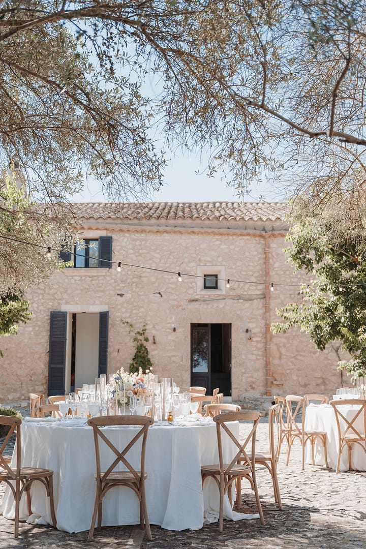 Outdoor Hochzeitsdinner auf Mallorca mit runden Tischen im Innenhof einer Finca – Weddingplanner und Eventplaner für Destination Weddings