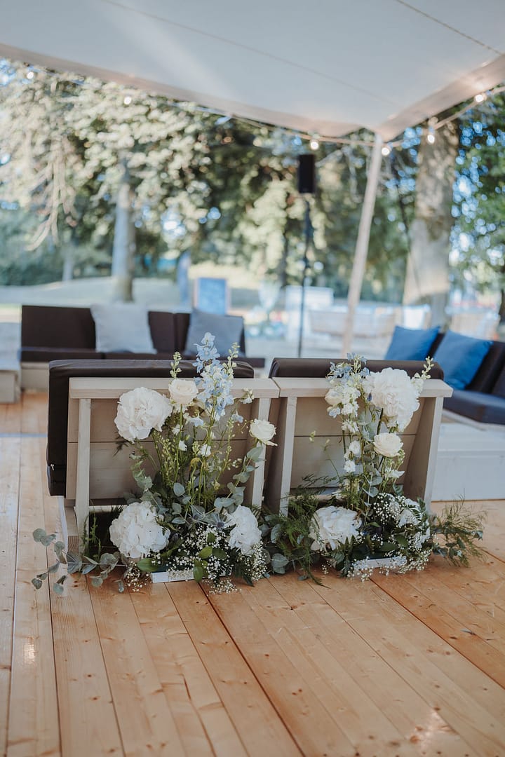 Lounge-Möbel und Blumendekoration bei einer Open-Air-Hochzeit, abgestimmt im Rahmen eines individuellen Hochzeitsdesigns.