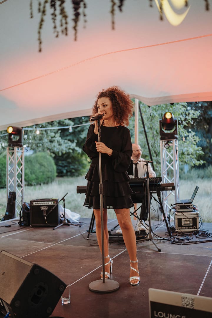Liveband auf einer Outdoor-Bühne bei einer Hochzeit im Grünen, umgesetzt im Rahmen einer umfassenden Eventplanung.