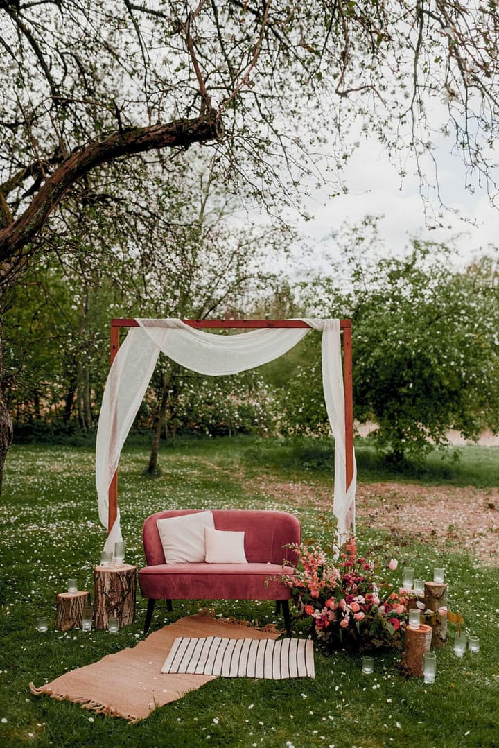 Persönliches Sofa-Setting als Mittelpunkt einer freien Trauung im Rahmen eines Outdoor-Wedding-Weekends.