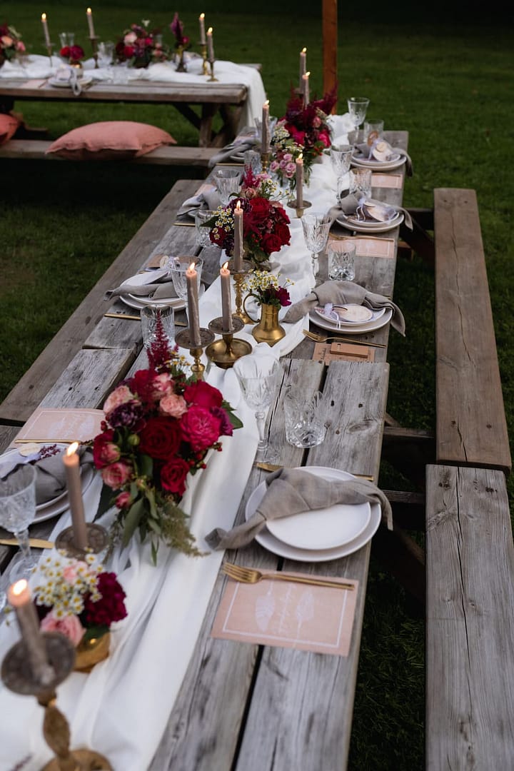 Abendliche Stimmung an einer eleganten Picknick Tafel Setting mit Kerzenlicht bei einem Outdoor-Hochzeitswochenende in einem AirBnB.