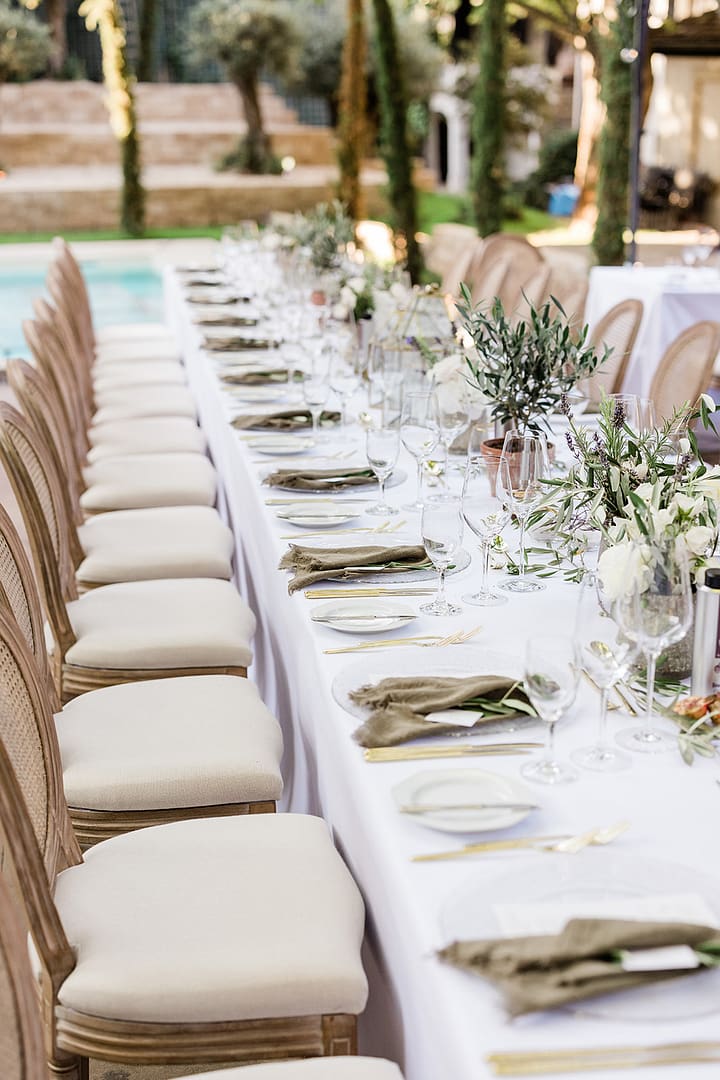 Lange Tafel am Pool als Teil eines sommerlichen Hochzeitswochenendes