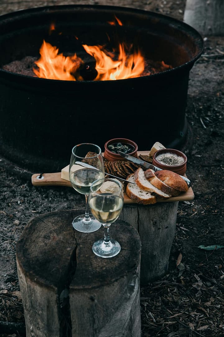 Lagerfeuer als stimmungsvoller Treffpunkt während eines Hochzeitsabends in der Natur.