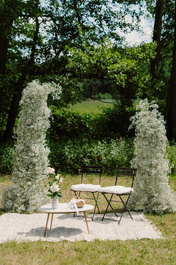 Florale Akzente und ruhige Naturtöne als Teil eines durchdachten Trauungsdesigns für eine Outdoor-Hochzeit.