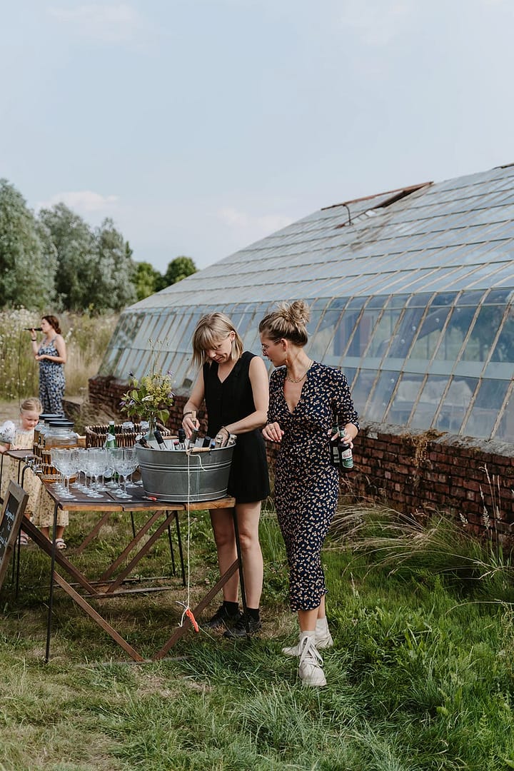 Hochzeitsplaner und Gäste bereiten Drinks bei einer Outdoor-Hochzeit im Garten vor – Beispiel für die Philosophie der Hochzeitsplanung mit entspannter Atmosphäre und persönlichem Gästeerlebnis.