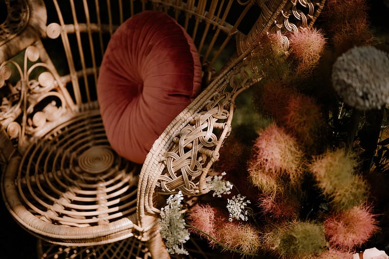 Peacock Chair mit eleganter Wildflower-Deko als Teil einer freien Trauung im Garten eines Airbnb-Ferienhauses.