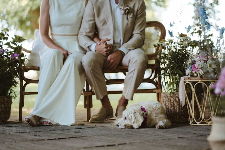 Brautpaar sitzt entspannt während der Trauung – persönliche Outdoor Hochzeit mit Hund