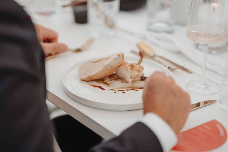 Servierter Hauptgang bei einer Gartenhochzeit auf einem privaten Anwesen während eines stilvollen Outdoor-Dinners