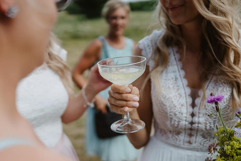 Sektempfang unter freiem Himmel bei einer ungezwungenen Outdoor Hochzeit