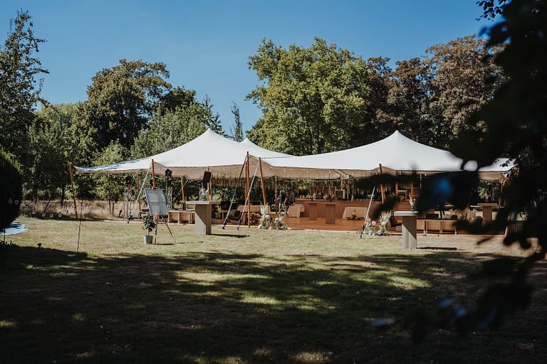 Zeltaufbau für eine Hochzeit im Schlosspark mit Holzfußboden und Eventstruktur, geplant von einem Hochzeitsplaner für Outdoor-Hochzeiten.