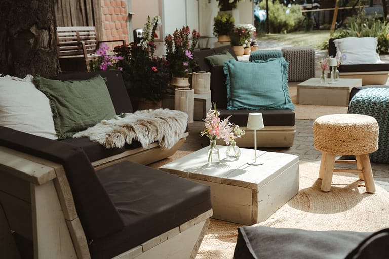 Lounge-Bereich einer exklusiven Zelthochzeit mit Sofas, Naturteppichen und floralen Details – Teil eines ganzheitlich geplanten Wedding Weekends auf privatem Anwesen.