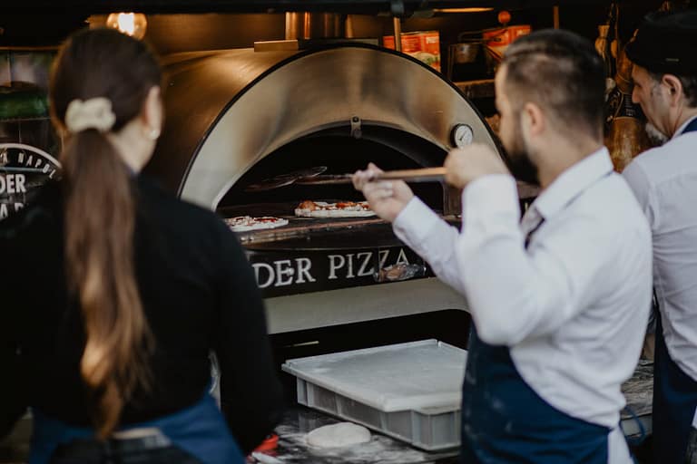 Frische Pizza aus dem Ofen als unkompliziertes und sehr beliebtes Food-Konzept bei einer Outdoor-Hochzeit.