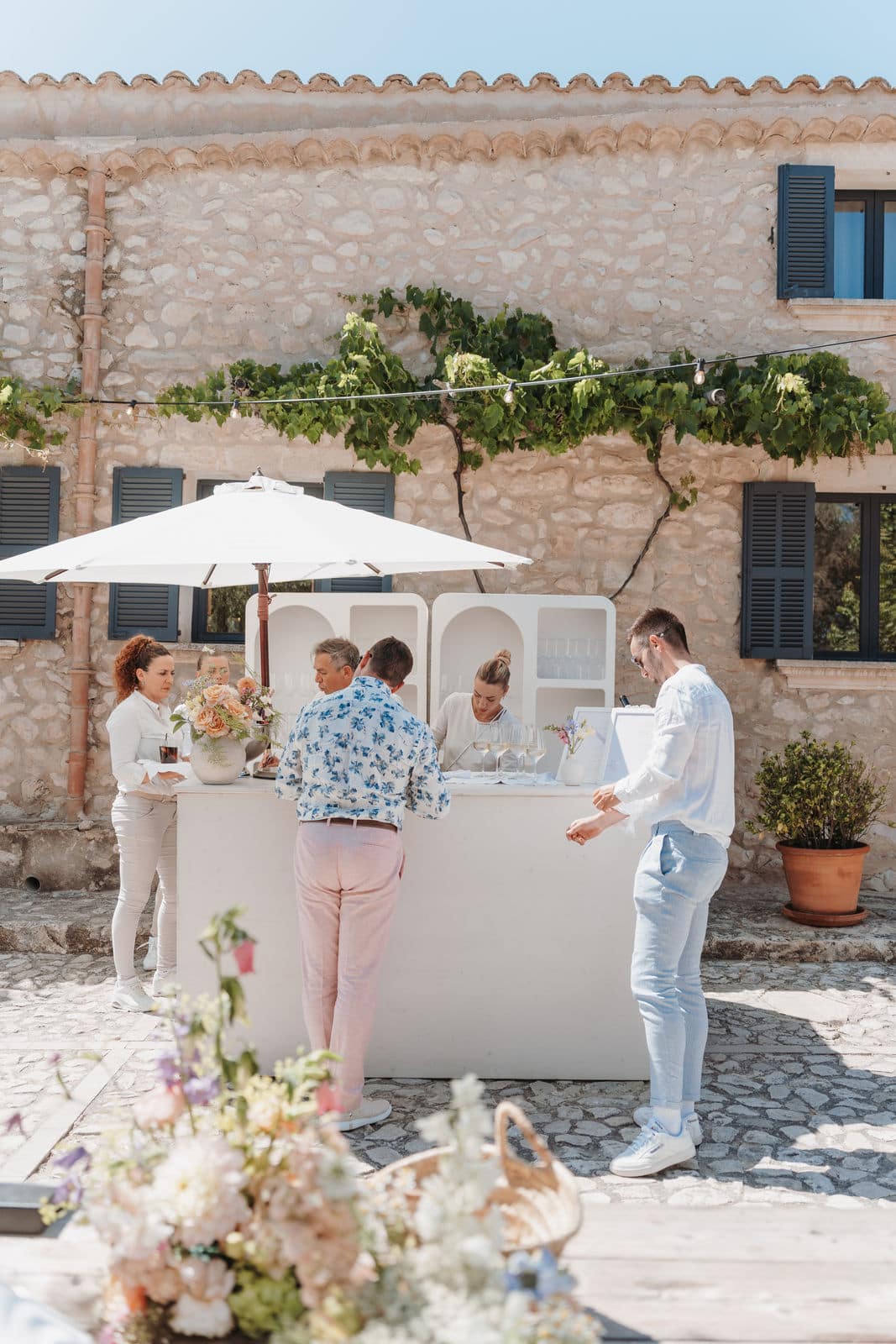 Gäste versammeln sich an einer Bar im Innenhof während einer Hochzeitsfeier
