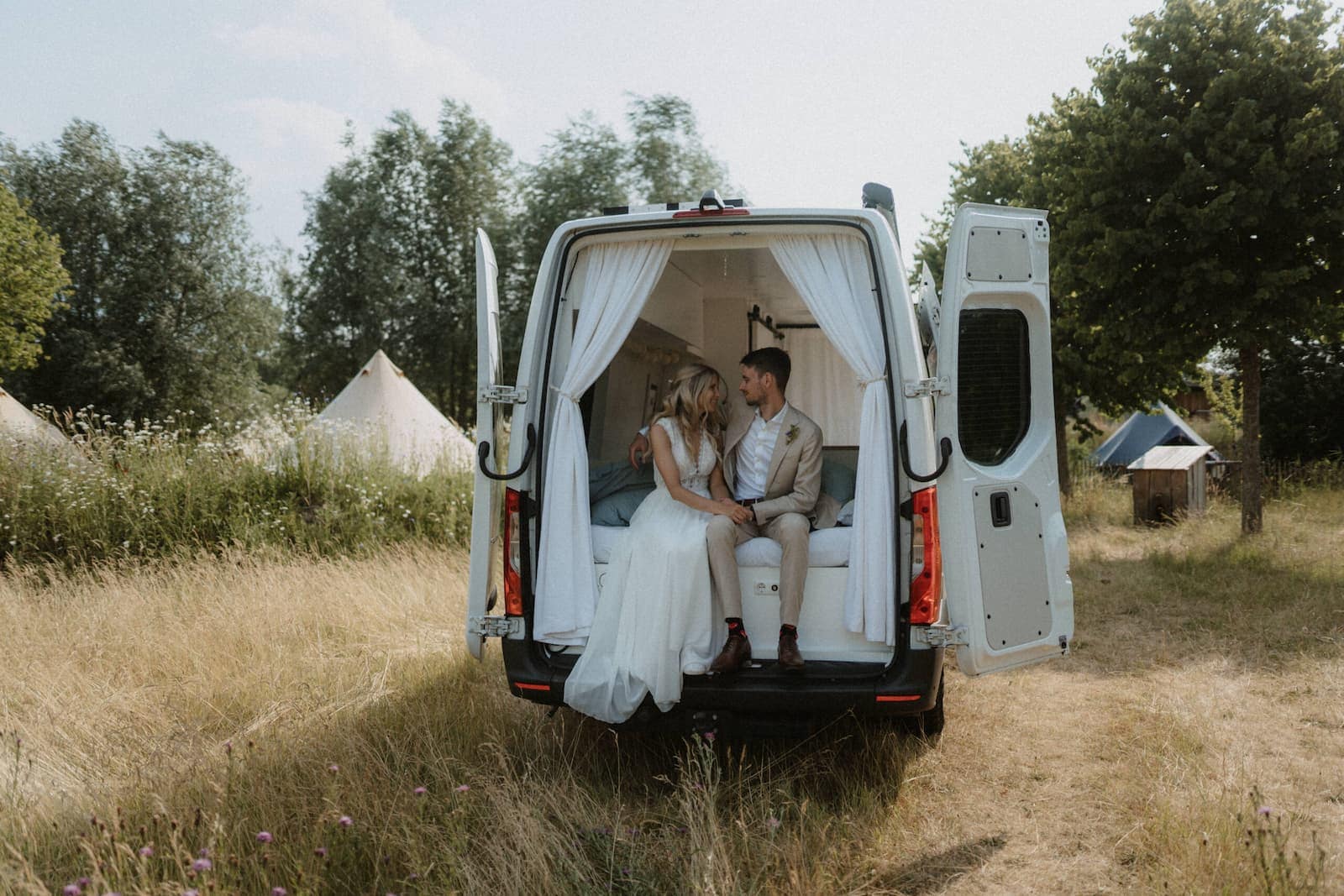 Brautpaar sitzt gemeinsam in einem Camper und genießt einen ruhigen Moment