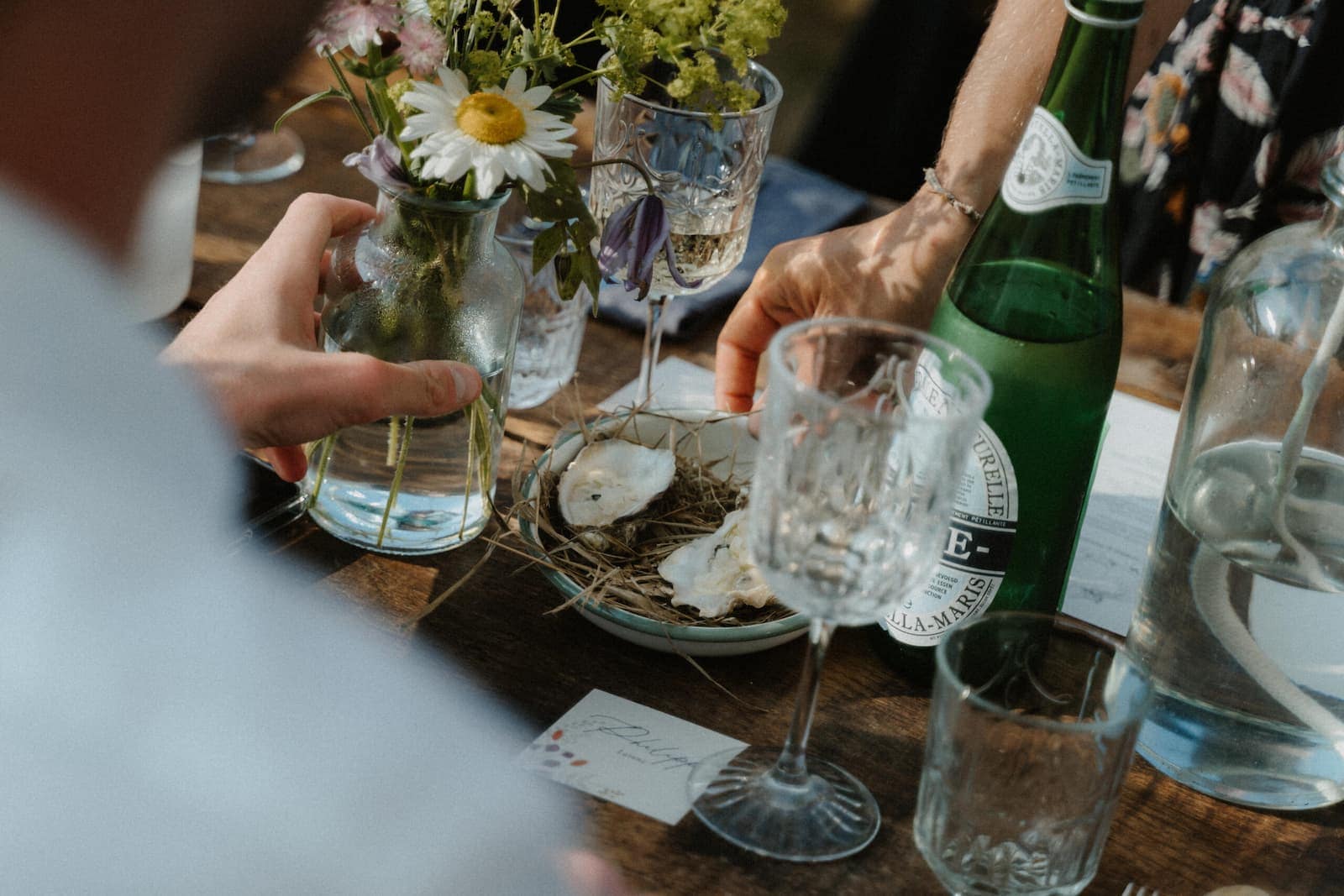 Detailaufnahme einer gedeckten Tafel mit Blumen, Gläsern und kleinen Speisen