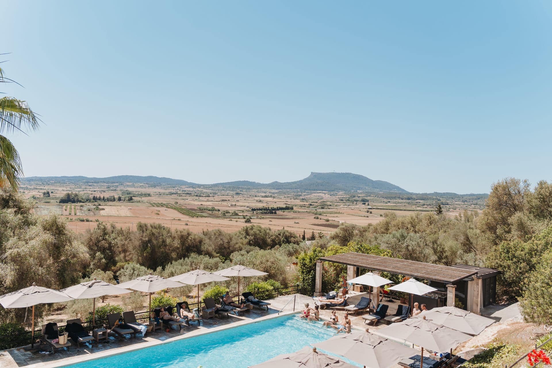 Gäste entspannen am Pool vor Beginn einer Hochzeitsfeier in ländlicher Umgebung