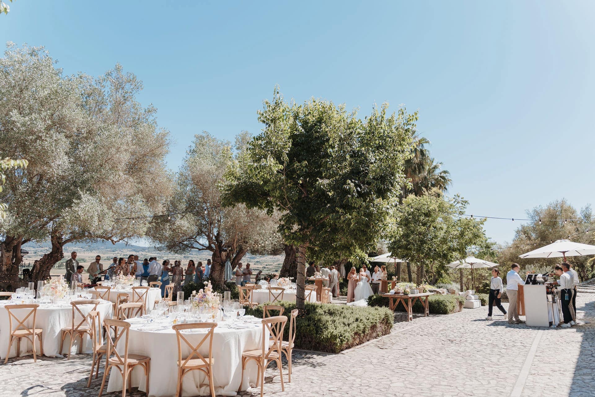 Gedeckte Tische im Freien für ein gemeinsames Hochzeitsdinner