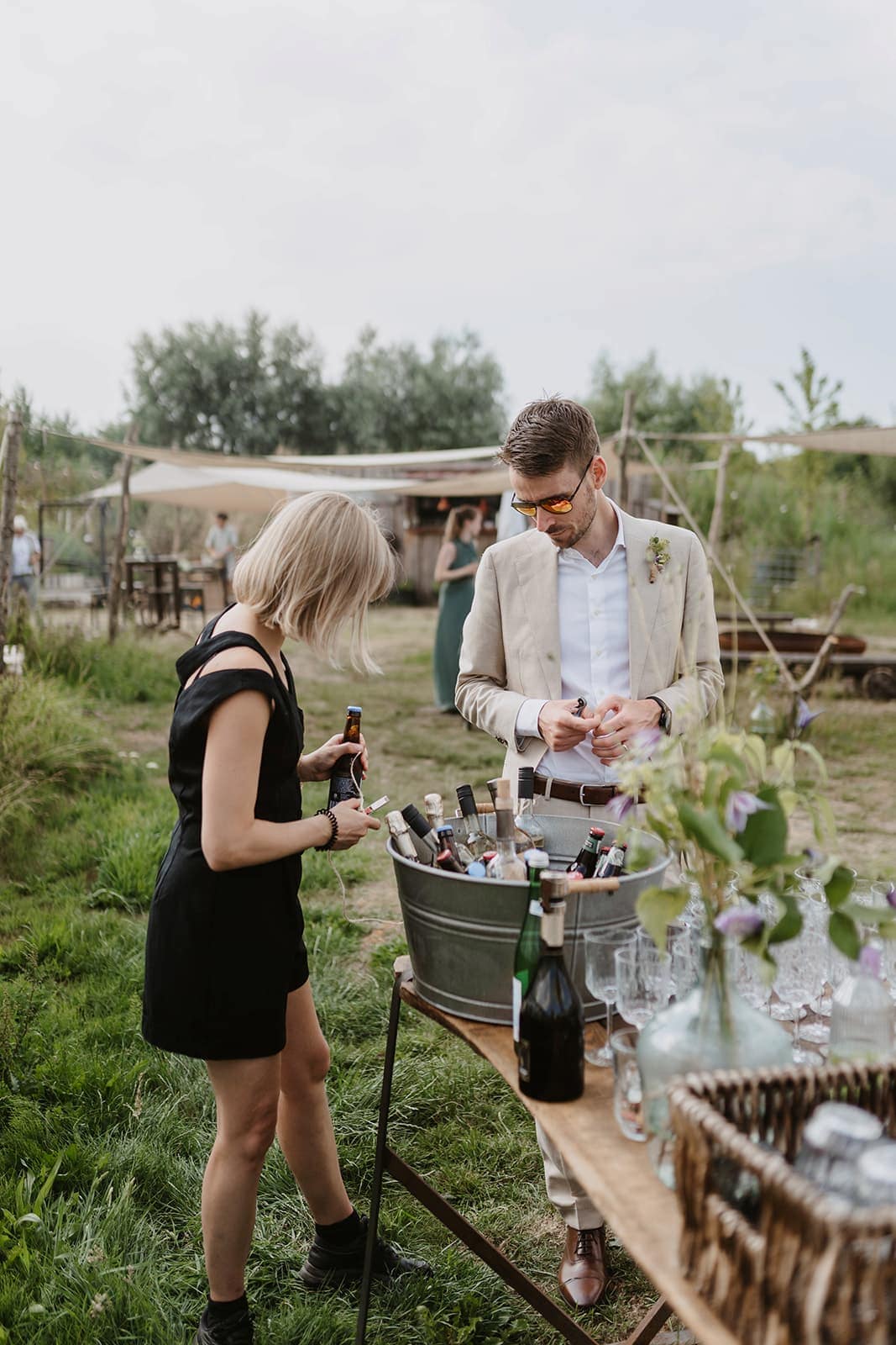 Gäste stehen an einer kleinen Getränkebar im Freien