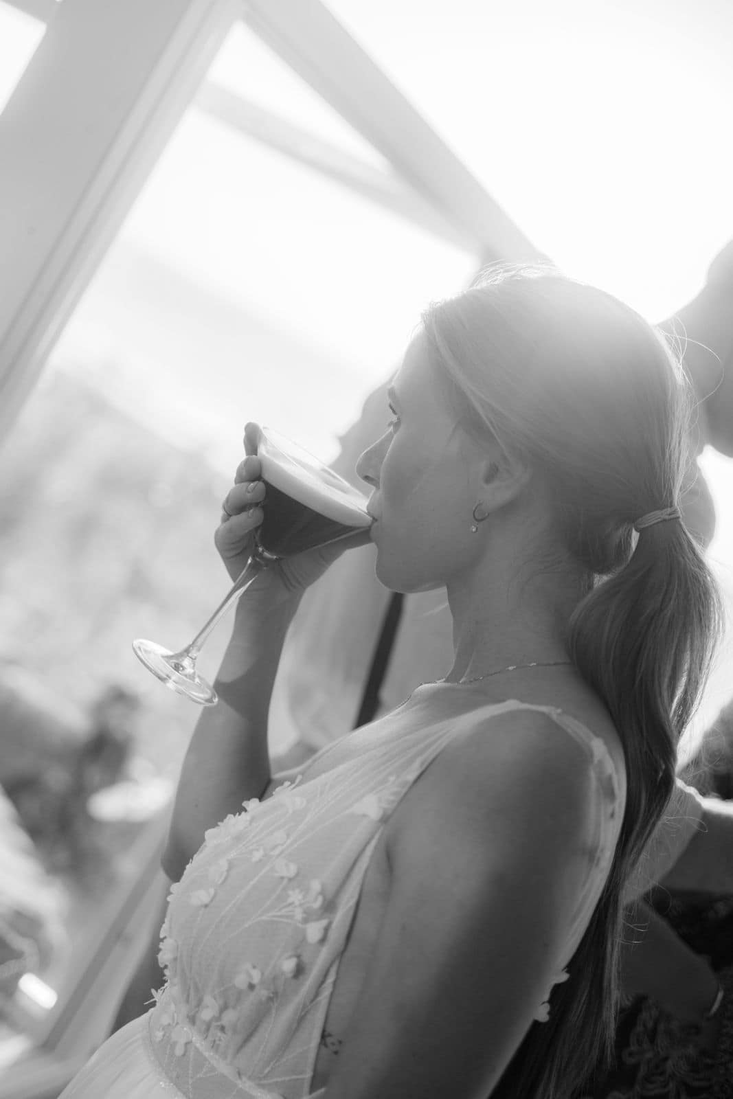 Braut bei einem entspannten Moment mit Espresso Martini während einer Hochzeit – authentische Hochzeitsreportage