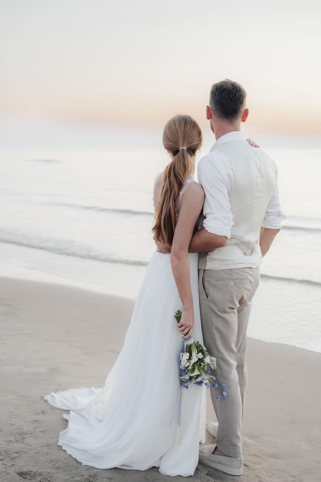 Brautpaar bei einer Hochzeit in Holland blickt gemeinsam auf das Meer