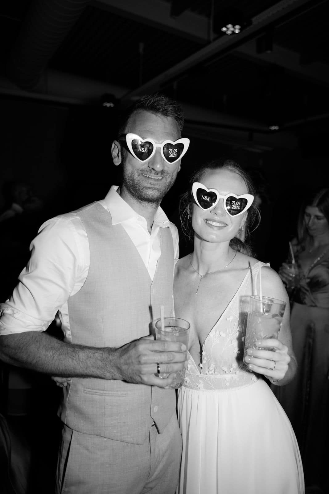 Brautpaar mit Herzbrillen feiert ausgelassen auf der Party einer Hochzeit in Holland