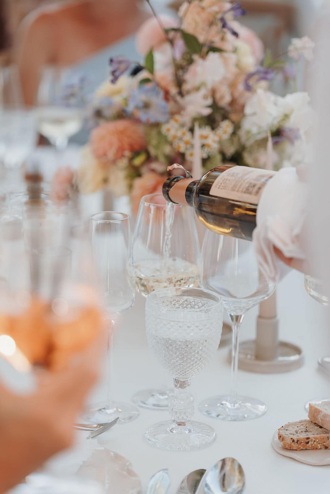 Entspannte Atmosphäre beim Hochzeitsdinner mit Wein und Blumendekoration