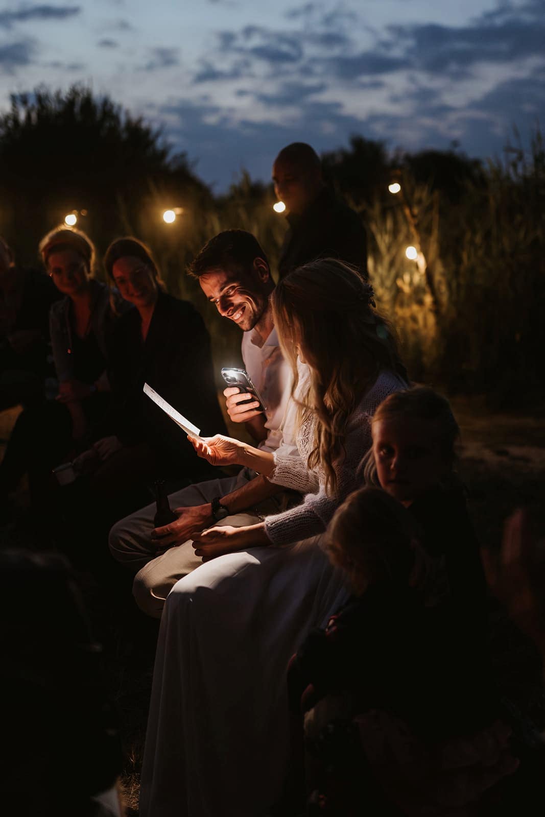Intimer Moment am Abend, während ein Text im Licht eines Handys vorgelesen wird