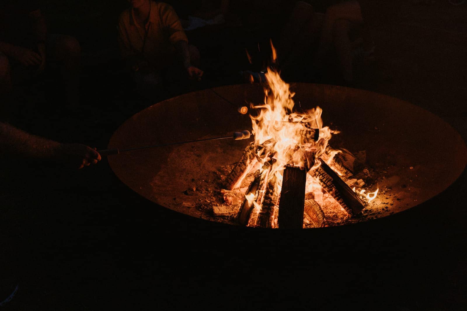 Lagerfeuer am Abend mit Gästen in entspannter Atmosphäre