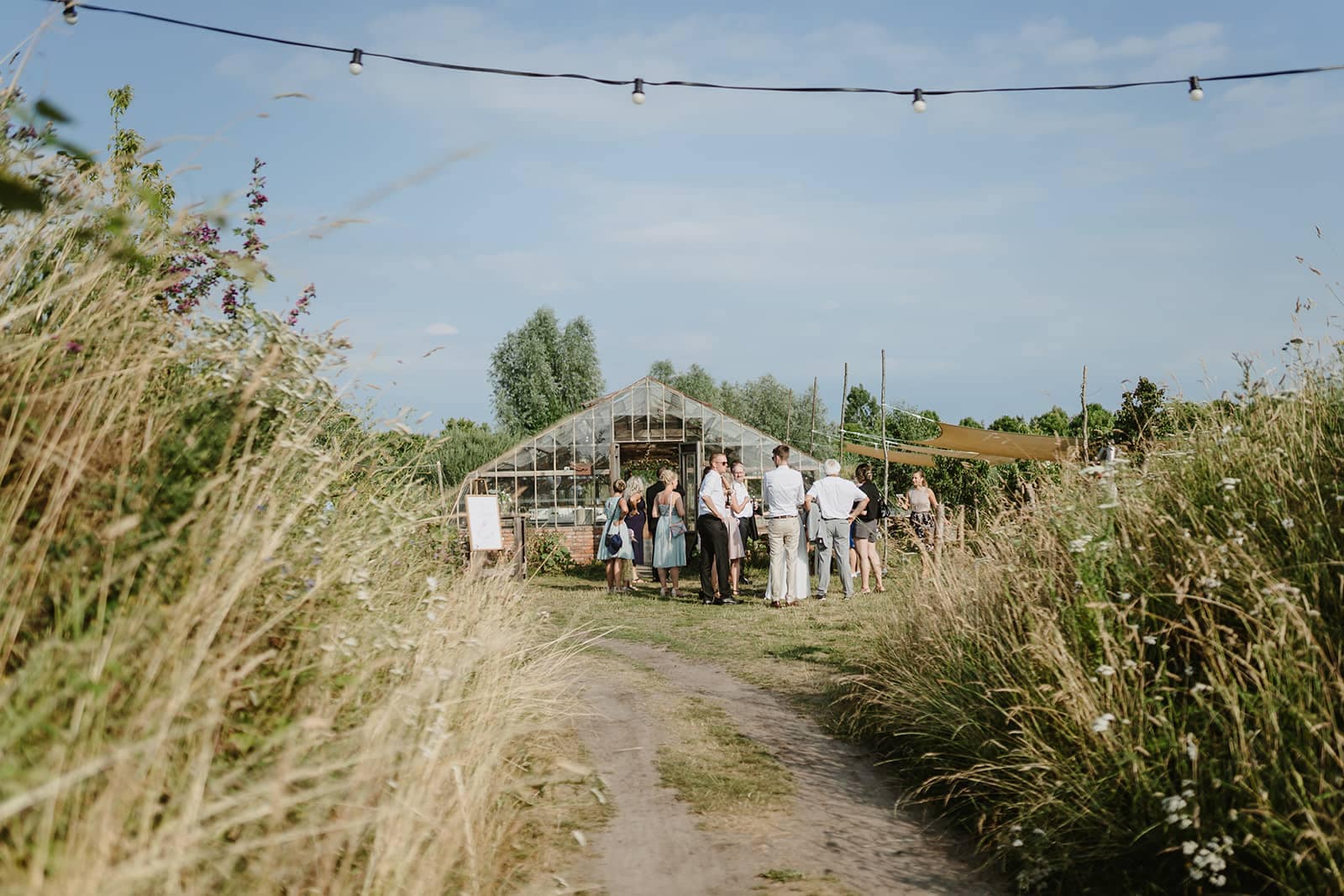 Gäste kommen über einen Naturweg zu einer Outdoor Hochzeit mit freier Trauung
