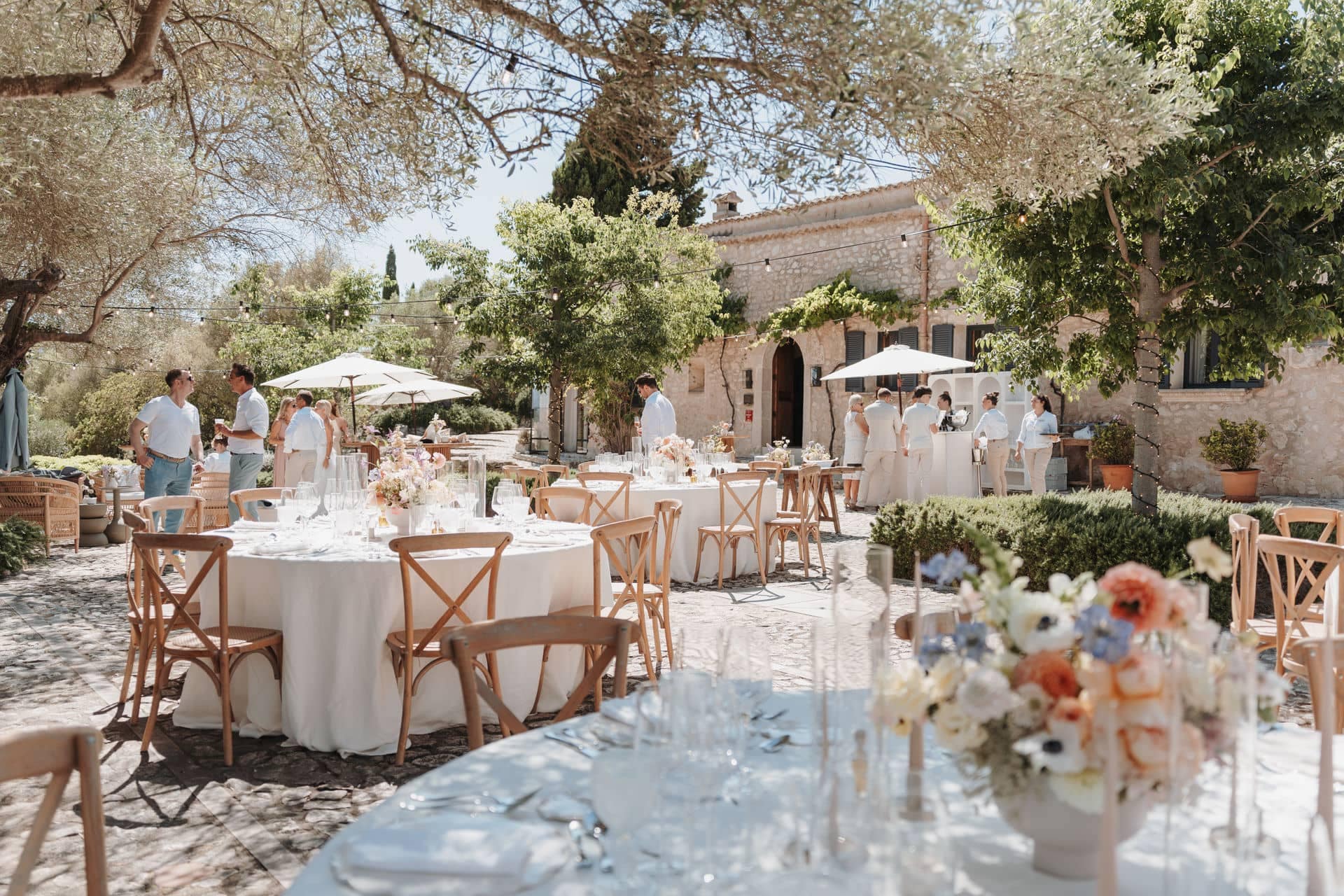 Outdoor-Hochzeitsfeier mit runden Tafeln im Rahmen einer professionellen Hochzeitsplanung
