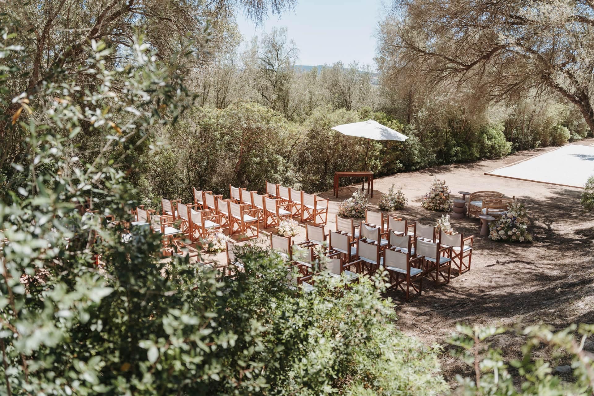 Übersicht über einen Outdoor-Trauungsort mit Stuhlreihen und Blumen in natürlicher Umgebung